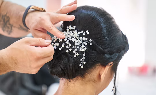 A jewelled hairpin being set into a bridal chignon at Glory