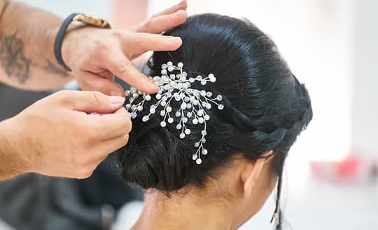 A jewelled hairpin being set into a bridal chignon at Glory