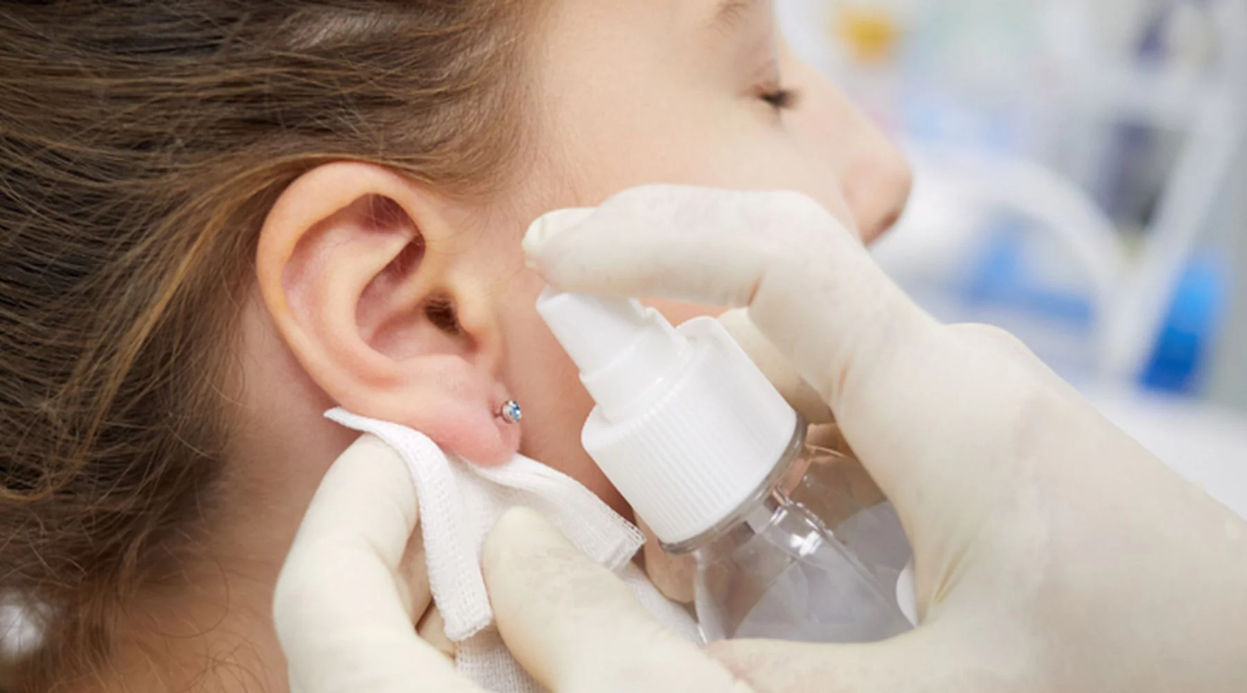 An ear being cleaned and prepared for a hygienic piercing