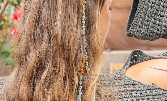 A colourful thread hair wrap tied around a section of long hair